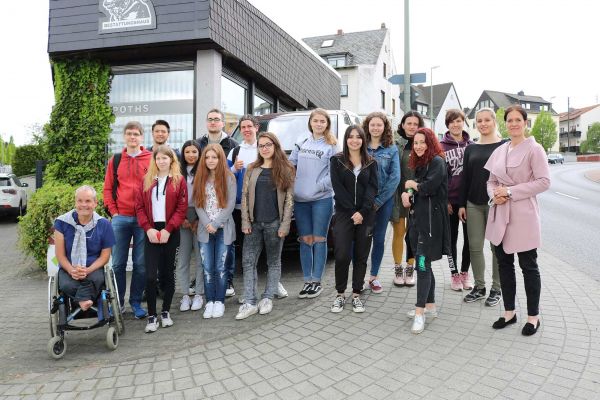 Bild der Seminargruppe mit Herrn Hundler und Frau Poths mit der Elzer Geschäftsstelle im Hintergrund